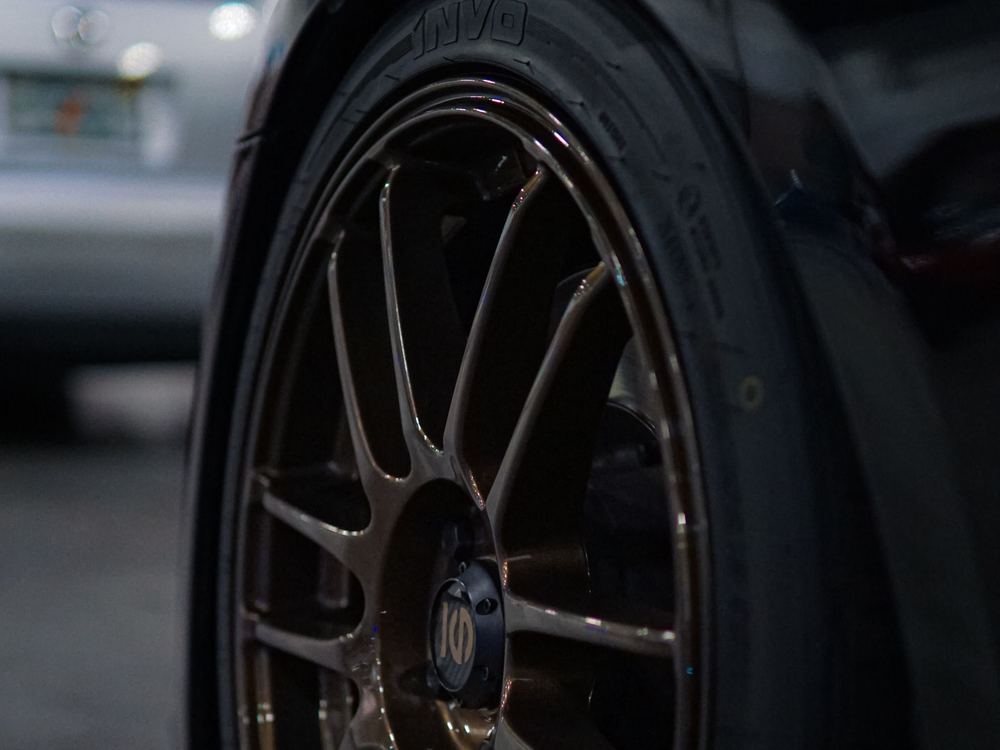 Bronze alloy wheel on a dark car in low light