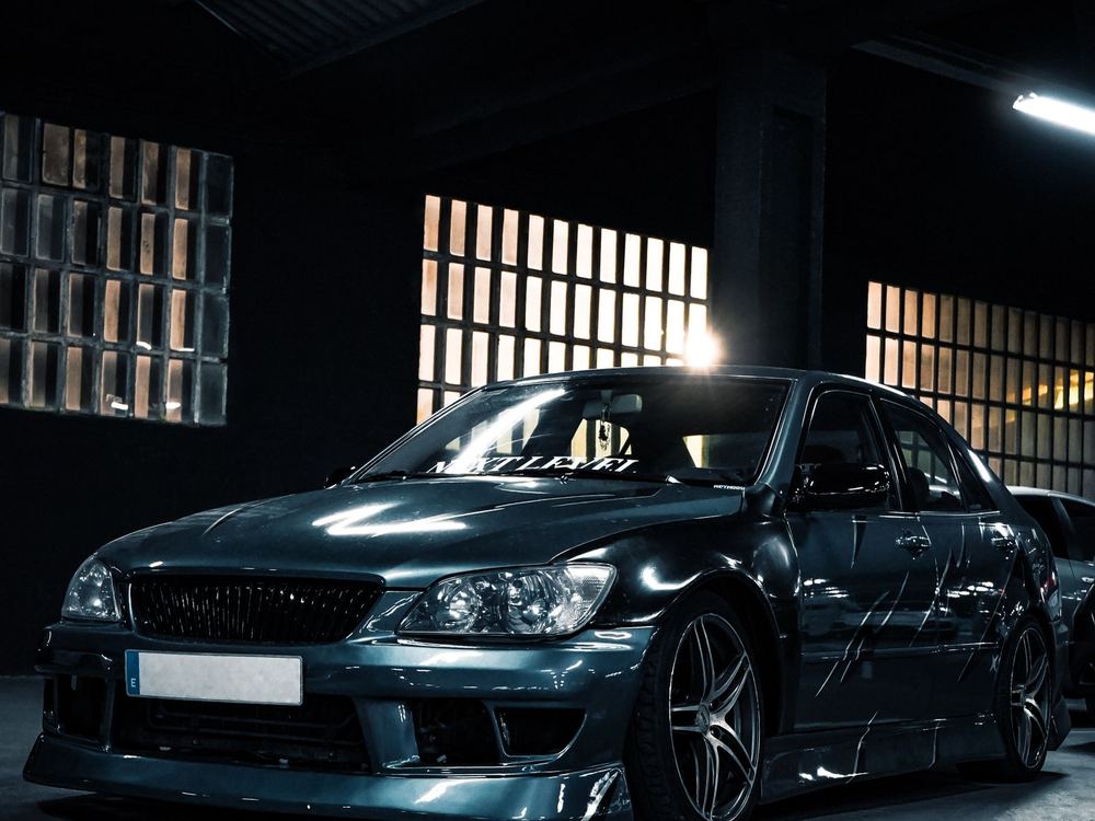 Black performance car in a dark garage with fresh paint