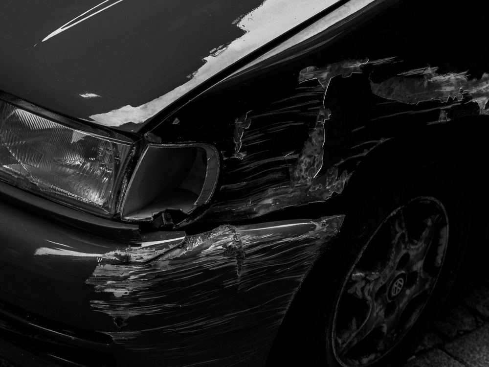 Crumpled front corner of a dark vehicle