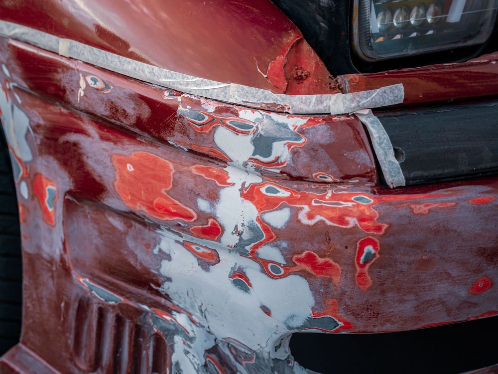 Front-end collision damage on a red vehicle