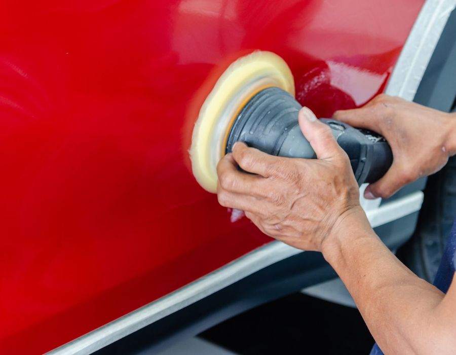 Machine polishing the paintwork of a red car