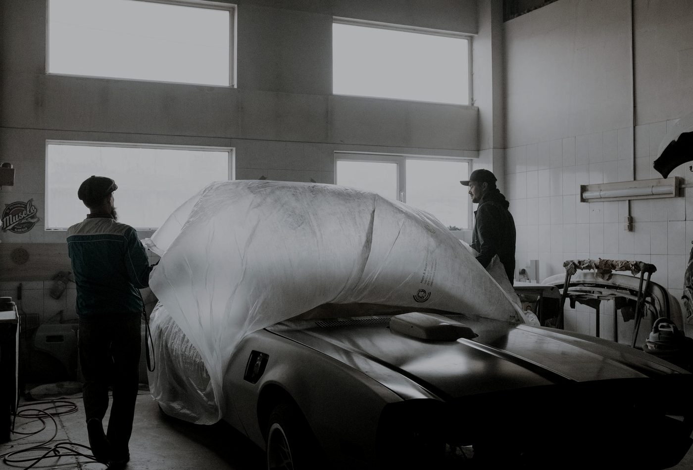Inside the Gear Up workshop with a vehicle under prep covers